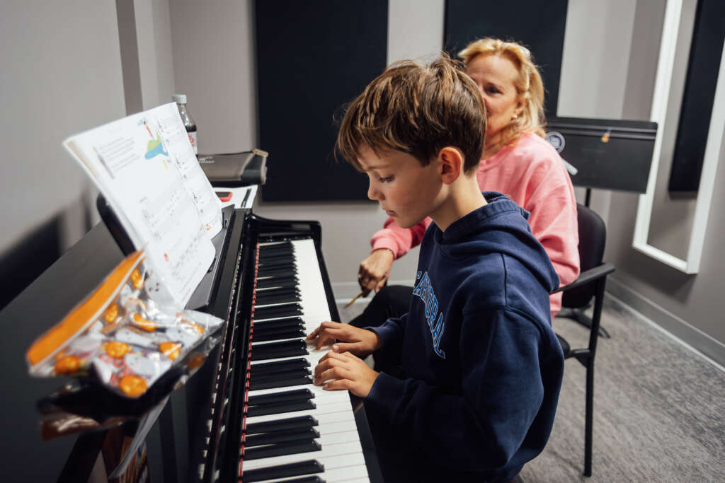 A student receives instruction on how to play piano